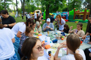 Park ortamında çeşitli kadın ve çocuklarla birlikte açık hava el sanatları atölyesi. 31 Mayıs 2024 Balti Moldova.