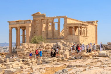 Bir grup insan bir sürü taşla birlikte bir binanın etrafında yürüyorlar. Bina eski görünüyor ve içinde bir sürü çatlak var. 9 Ağustos 2024 Atina Yunanistan