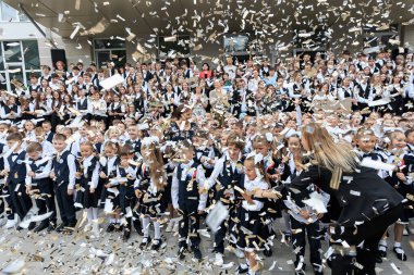 Konfeti ortasında mutlu çocuklar ve öğretmenlerle okulun açılışını kutluyoruz. 2 Eylül 2024 Balti Moldova.