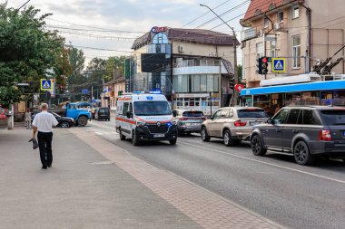 Gündüz vakti kalabalık şehir caddesinde yaya ve trafiği olan bir ambulans. 11 Eylül 2024 Balti Moldova.