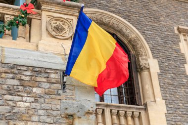 Romen bayrağı, tarihi taş bina üzerinde noel süsüsüyle.