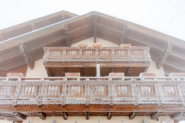 Kış sisinde karla kaplı ahşap dağ evi balkonunda.