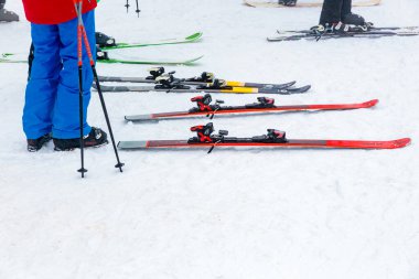 Karlı zeminde kayak ve direkleri olan karlı bir kayak merkezi. 15 Aralık 2024 'te Romanya.