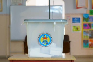 Moldova oy kullanma merkezinde ulusal amblemli saydam oy sandığı. 21 Kasım 2021 Balti, Moldova.