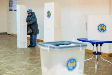 Kafkasyalı yaşlı bir kadın oy sandığıyla oy veriyor. 20 Ekim 2024 Balti, Moldova.