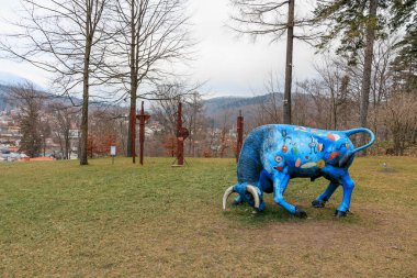 Mavi boğa heykeli çimenli bir arazide. 15 Aralık 2024 Busteni Romanya.