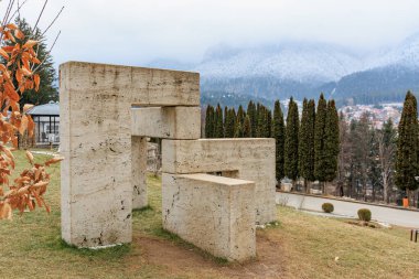 Büyük taş heykel çimenli bir tepede. 15 Aralık 2024 Busteni Romanya.