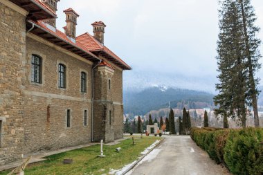Kırmızı çatılı büyük tuğla bina, Cantacuzino Kalesi. 15 Aralık 2024 Busteni Romanya.