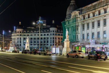 Tarihi heykelleri ve yoğun trafiği olan gece manzarası. 8 Mart 2025 Bükreş Romanya.