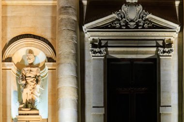 Tarihi yapı üzerine aydınlatılmış klasik heykel ve mimari detaylar. 8 Mart 2025 Bükreş Romanya.