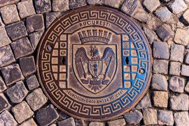 Bükreş 'teki rögar kapağında kaldırım taşı amblemi var. 8 Mart 2025 Bükreş Romanya.