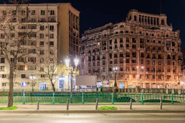 Geceleri aydınlatılmış binalarla tarihi Avrupa mimarisi yapıları. 8 Mart 2025 Bükreş Romanya.