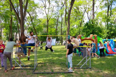 Çeşitli kalabalıklar oyun ekipmanlarıyla parkın keyfini çıkarıyorlar. 31 Mayıs 2024 Balti Moldova.