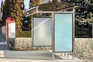 Şehir ortamında cam panelleri olan boş modern otobüs durağı.