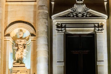 Geceleri aydınlık taş heykel ve klasik mimari.