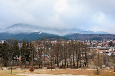 Kış başında karlı tepeleri ve orman manzarası olan manzaralı dağ kasabası..