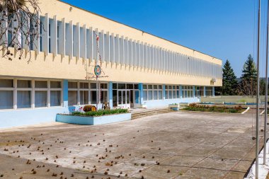Terk edilmiş, mavi gökyüzü geçmişi olan bir okul bahçesi. 2 Mayıs 2023 Romanesti Moldova.