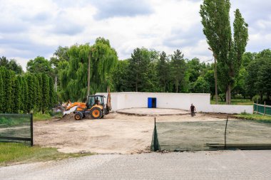 Kazı işçisi ve parktaki inşaat alanında çalışan olgun ağaçlar. 29 Haziran 2023 Beltsy Moldova.