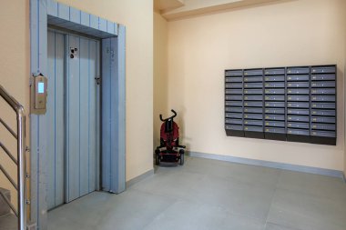Posta kutuları ve apartmanında kırmızı bebek arabası olan asansör lobisi. 29 Eylül 2023 Balti Moldova.