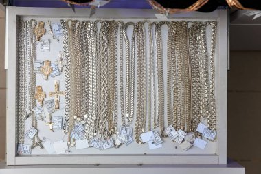 Kuyumcu çekmecesinde haç kolyeli altın ve gümüş zincirler sergileniyor. 3 Kasım 2023 Balti Moldova.