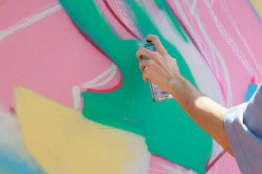 Erkek el sprey boyayla renkli grafiti sanatı yaratıyor. 31 Mayıs 2024 Balti Moldova.