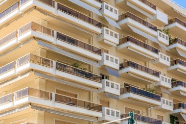 Balkonları ve tenteleri olan yüksek bir bina. Balkonlar boş. Bina beyaz. 8 Ağustos 2024 Selanik Yunanistan