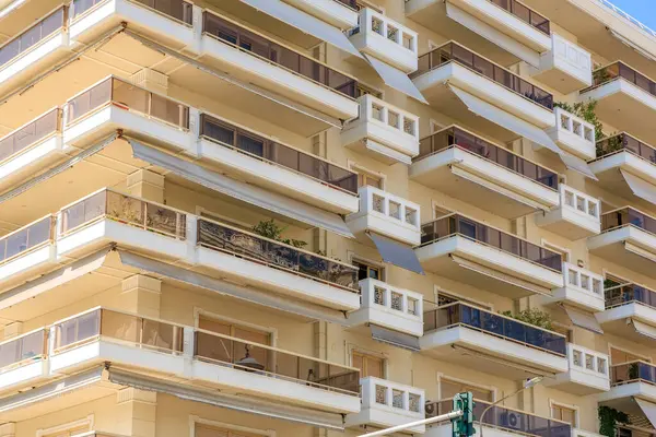 Balkonları ve tenteleri olan yüksek bir bina. Balkonlar boş. Bina beyaz. 8 Ağustos 2024 Selanik Yunanistan