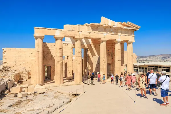 Bir grup insan sütunları olan bir binada yürüyorlar. Bina eski ve bir sürü tarihi var. 9 Ağustos 2024 Atina Yunanistan