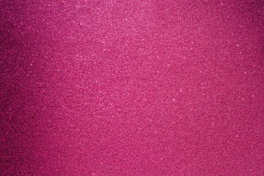 Pembe bir arka plan ve bir sürü parıltı. Parıltı farklı boyutlarda ve her yere saçılmış.