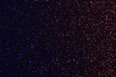 Koyu mavi ve kırmızı bir arka plan ve bir sürü parıltı. Parıltı tüm arka plana yayılmış ve yıldızlı bir gece gibi görünüyor.