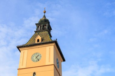 Üzerinde saat olan uzun bir saat kulesi. Gökyüzü açık ve mavi