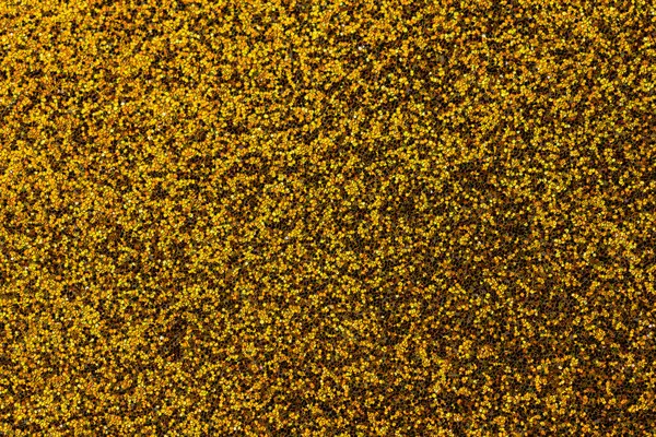 Sarı ve kahverengi benekli sarı bir halıya yakın çekim. Halı çok desenli ve çok detaylı.