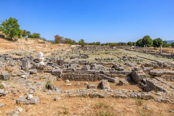 Arka planda mavi bir gökyüzü olan büyük, boş bir alan. Alan büyük taşlarla dolu ve çok çorak bir görünüme sahip. Yunanistan 'ın antik Filippi kentinin kalıntıları