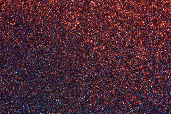 Kırmızı ve mavi ışıltılı bir arka plan. Arka plan pek çok küçük parıltı parçasından oluşur.