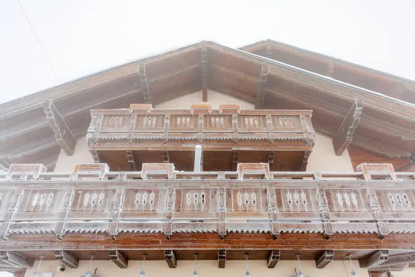 Kış manzarasında kırsal kar kaplı ahşap dağ evi balkonu.