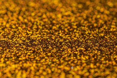 Görüntü, altın parıltılı bir yüzeye yakındır. Altın rengi çok parlak ve parlak, ve parıltı yüzeye bir hareket ve derinlik hissi katıyor. Sahne lüks ve zenginliktir.