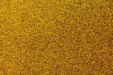 Bir sürü küçük altın tanecikli altın bir arka plan. Altın parlak ve parlaktır. Arkaplan resmin ana odak noktasıdır