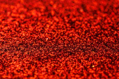Kırmızı parıltılı malzemeden yakın çekim. Kırmızı renk çok parlak ve göze çarpıyor. Parlak dokusu görüntüye bir hareket ve enerji hissi ekler.
