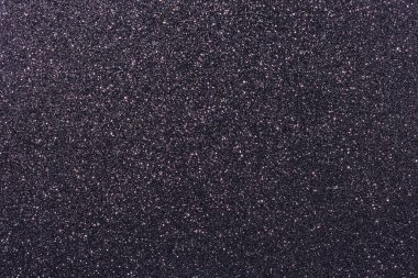 Bir sürü küçük noktalı siyah ve mor bir arkaplan. Arka plan koyu renkli ve noktalar küçük ve dağınık.