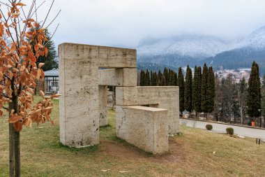 Büyük beton yapı çimenli bir arazide. 15 Aralık 2024 Busteni Romanya.