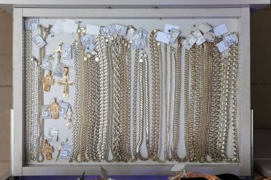 Vitrinde çeşitli gümüş zincirler ve haç kolyeler var. 3 Kasım 2023 Balti Moldova.