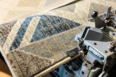 Endüstriyel dikiş makinesiyle kaplanmış halı. 9 Ocak 2024 Balti, Moldova.