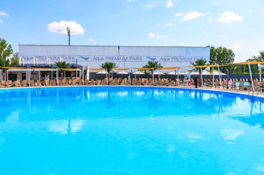 Arkasında beyaz bir bina olan büyük bir havuz. Havuz şemsiyeler ve sandalyelerle çevrilidir. 8 Haziran 2024 Balti Moldova