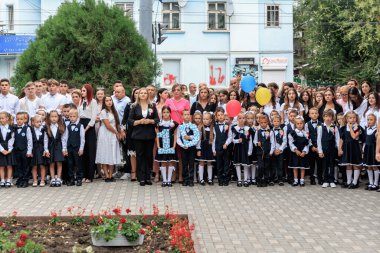 Öğretmenleri ve çocukları olan bir okul grubu ellerinde balonlar ve açık hava tabelasıyla. 2 Eylül 2024 Balti Moldova.