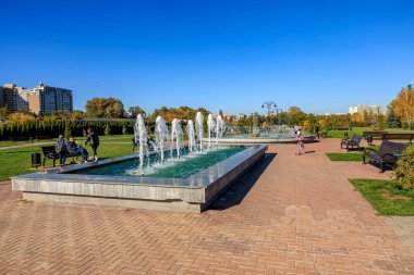 Çeşmeli ve birkaç banklı bir park. Çeşme tuğla bir geçitle çevrilidir. 27 Ekim 2024 Chisinau Moldova