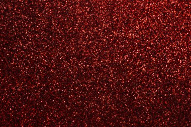 Kırmızı arka planda bir sürü kırmızı parıltı var. Parıltı tüm arka plana saçılmış.