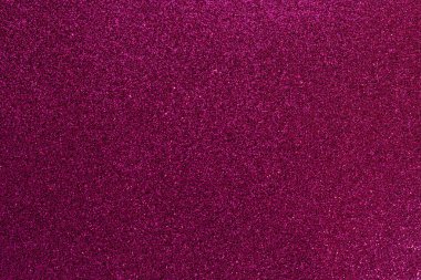 Mor parıltılı bir yüzeye yakın çekim. Yüzey küçük, parlak, renkli beneklerle kaplı. Görüntü rüya gibi, ruhani bir kaliteye sahip, sanki parıltı havada süzülüyor.