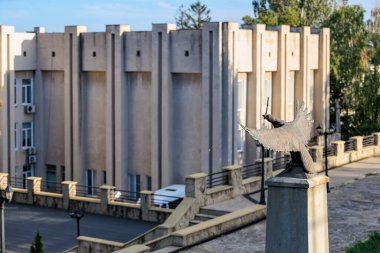 Modern beton binaya bakan bronz kuş heykeli. 13 Ekim 2024 Cimislia Moldova.