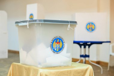 Romanya oy kullanma merkezinde kapalı kapaklı ve resmi amblemli saydam oy sandığı. 20 Ekim 2024 Balti, Moldova.