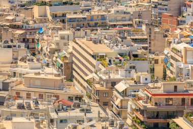 Bir sürü binası ve mavi gökyüzü olan bir şehir manzarası. Binaların çoğu beyaz ve gökyüzü temiz. 9 Ağustos 2024 Atina Yunanistan